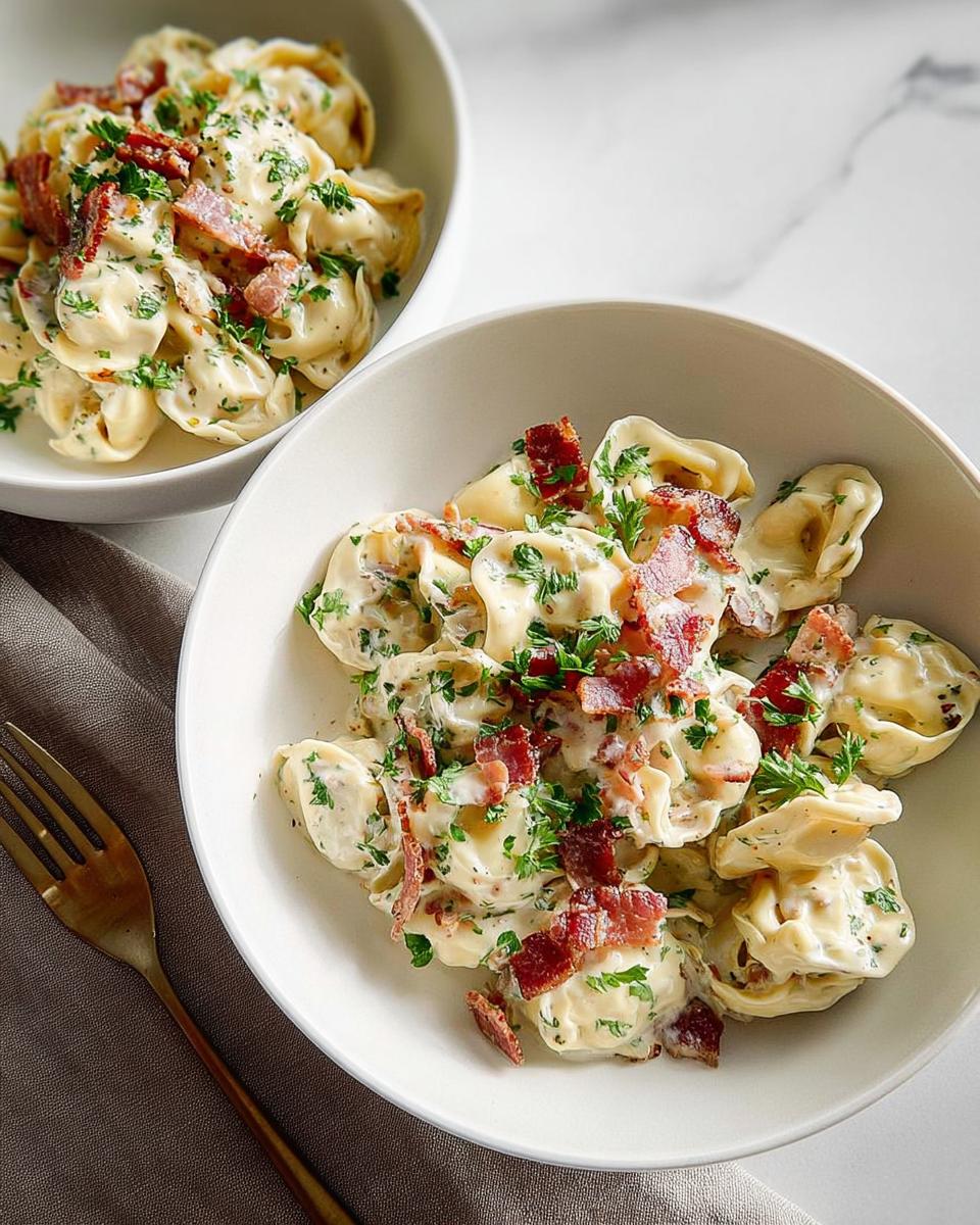 Two bowls of creamy tortellini pasta with crispy bacon bits and fresh parsley, a perfect 5-ingredient pasta recipe.