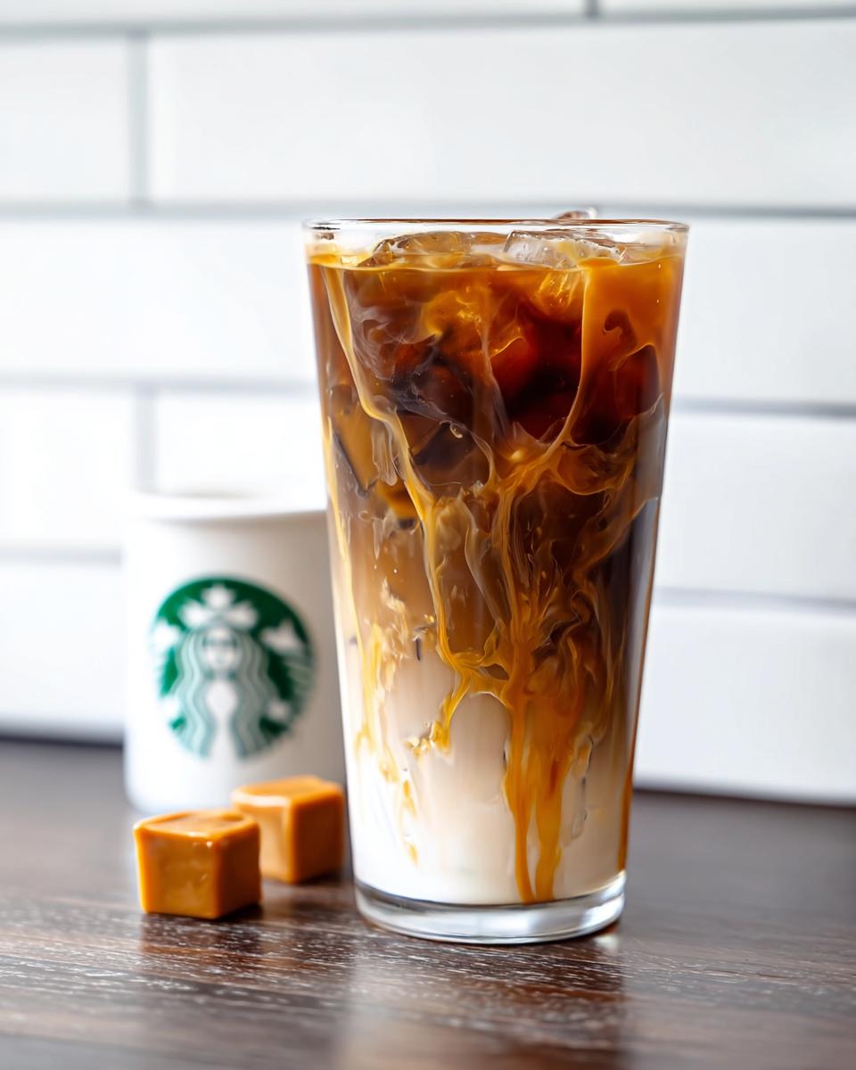 Close-up of a Café-Style Iced Caramel Macchiato (Copycat) showing caramel swirling into milk and espresso over ice.