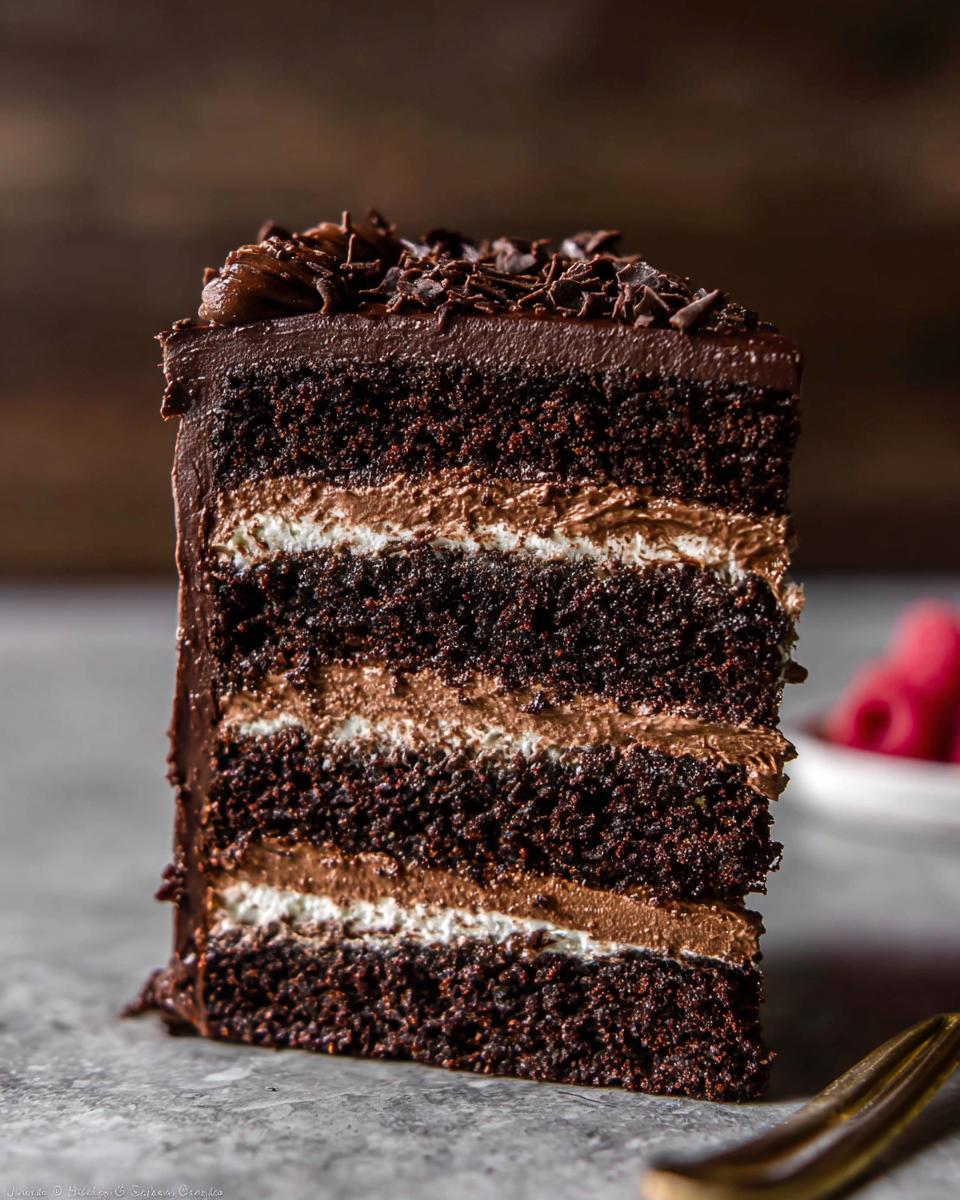 Close-up of a decadent slice of Chocolate Mousse Layer Cake showing four dark chocolate cake layers and rich mousse filling.