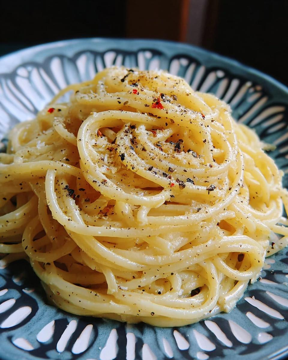 Close-up of creamy spaghetti with black pepper and red pepper flakes, a perfect dinner idea.