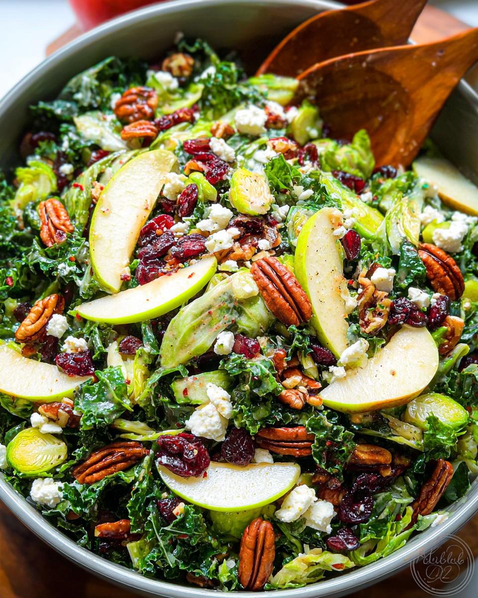 A vibrant One-Pan Thanksgiving Salad featuring kale, Brussels sprouts, apple slices, pecans, cranberries, and feta cheese.
