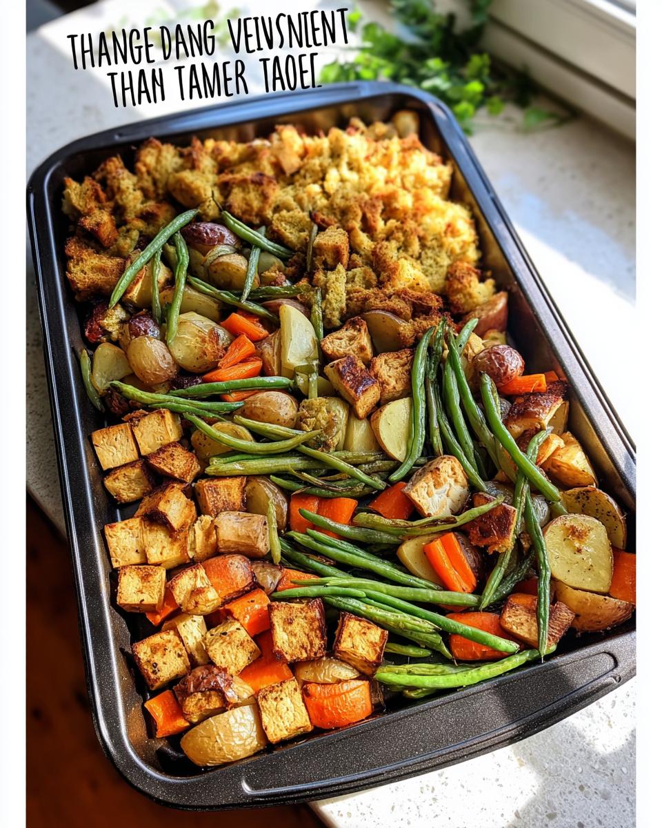 A close-up of a one-pan Thanksgiving veggie tray featuring roasted potatoes, carrots, green beans, tofu cubes, and stuffing.