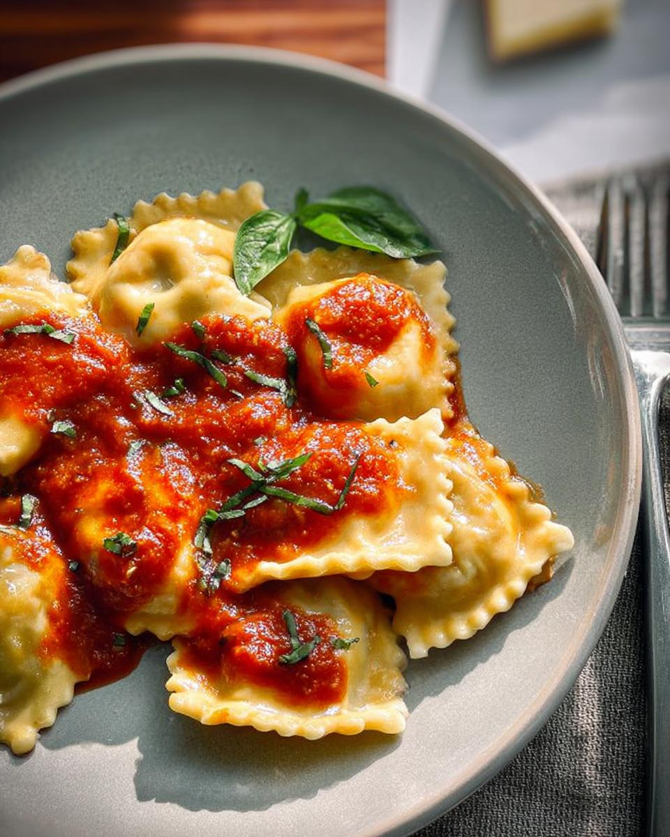 A plate of ravioli pasta recipes recipe topped with rich tomato sauce and fresh basil.