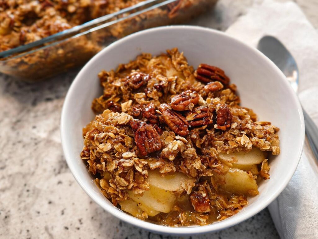 A bowl of warm apple crumble with pecans, perfect for Thanksgiving Desserts in 20 Minutes.