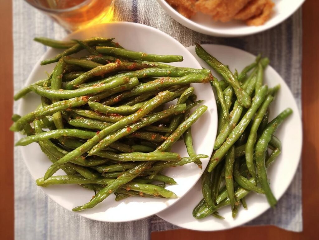 Two plates of glistening, seasoned green beans, perfect for Thanksgiving or any busy weeknight meal prep.