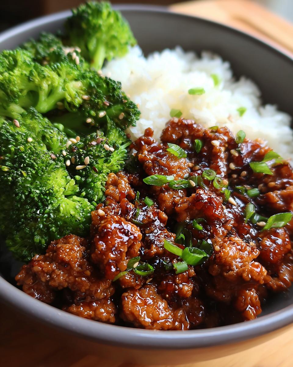 Close-up of a bowl featuring glazed honey garlic ground turkey, white rice, and steamed broccoli florets.