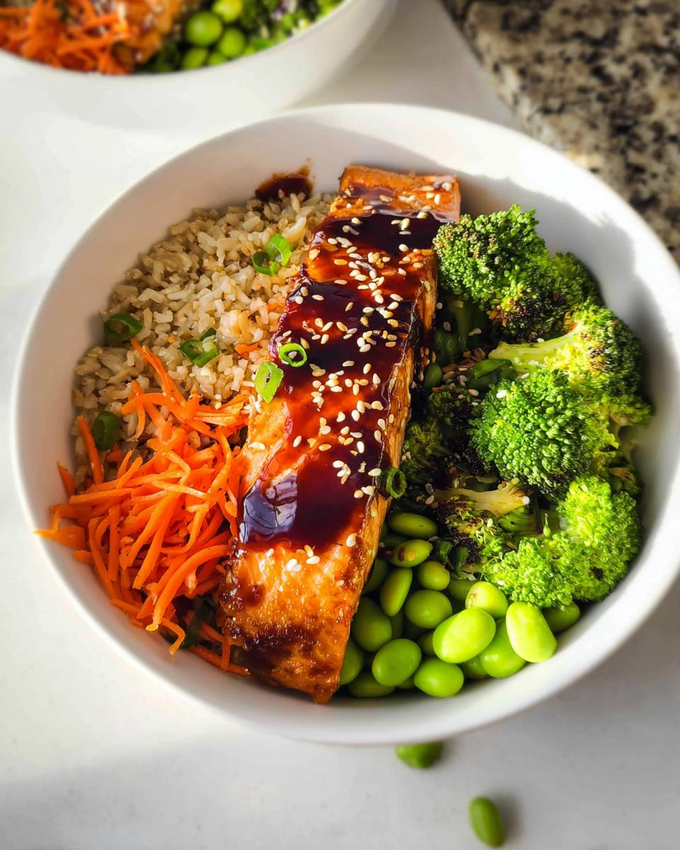 A close-up of a Healthy Teriyaki Salmon and Broccoli Bowl featuring glazed salmon, brown rice, and bright green vegetables.