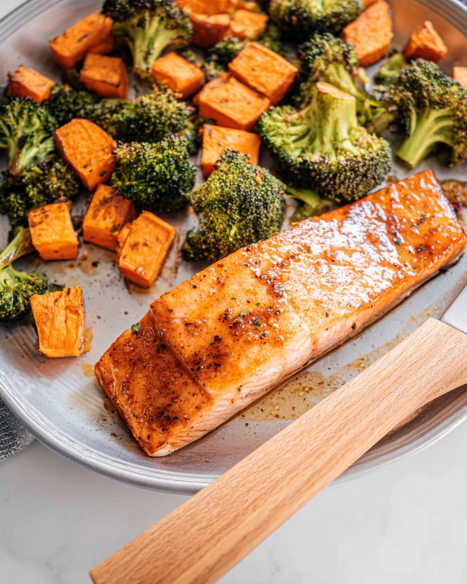 Close-up of a perfectly cooked Maple Dijon Salmon Sheet Pan Dinner with roasted broccoli and sweet potatoes.