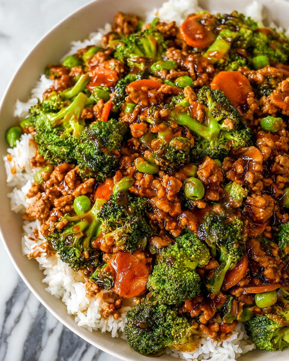 A close-up of a Teriyaki Ground Turkey Bowl featuring ground turkey, bright green broccoli florets, carrots, and edamame over white rice.