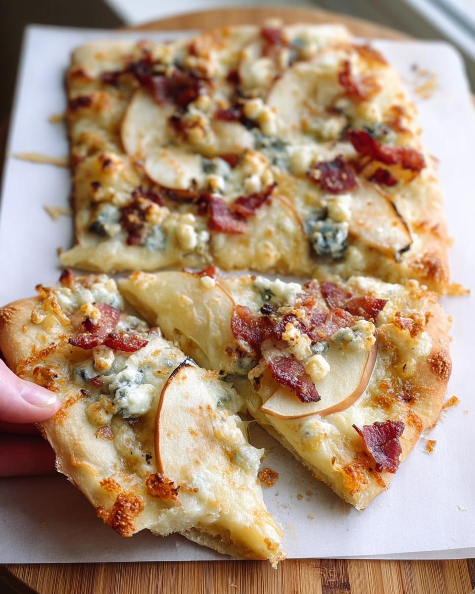 A slice of pear and bacon pizza with blue cheese and melted mozzarella, part of 10-Ingredient Pizza Night Recipes.