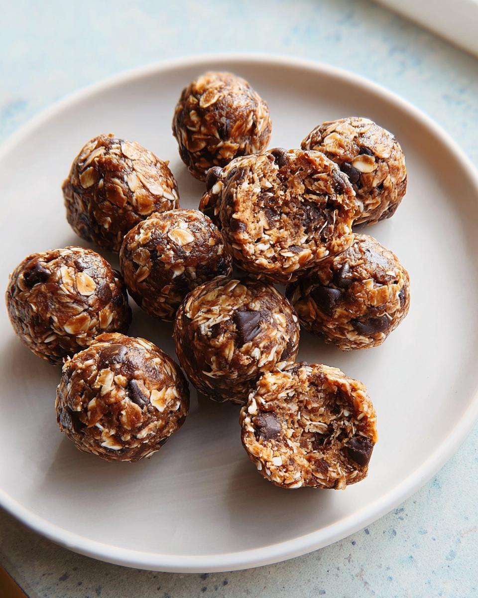 A pile of chocolate chip energy balls, a perfect addition to breakfast ideas recipes, with one ball broken open to show the texture.