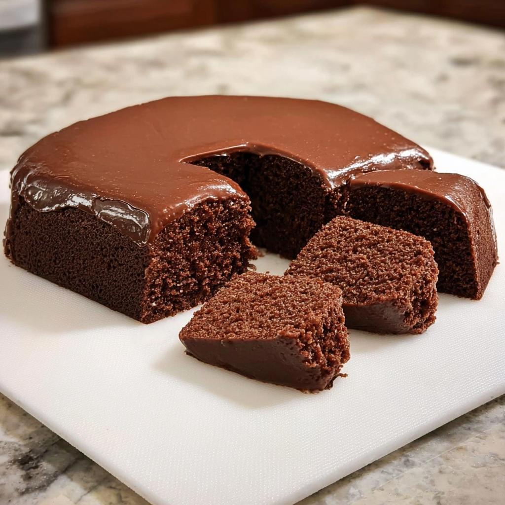 A rich chocolate cake with glossy frosting, sliced to reveal its moist crumb. Perfect for your cake ideas recipes.