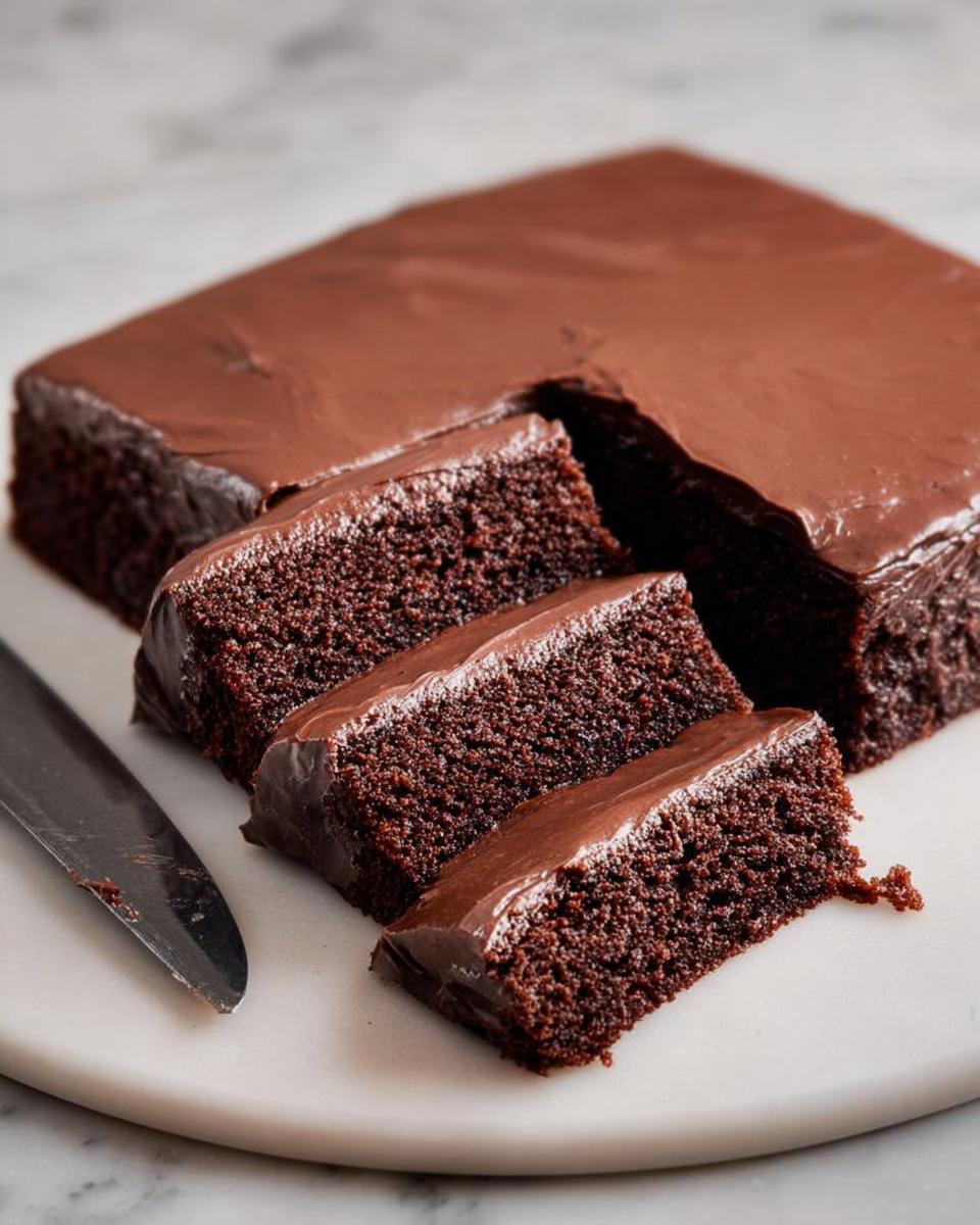 Close-up of moist chocolate cake ideas recipes, sliced and topped with rich chocolate frosting.