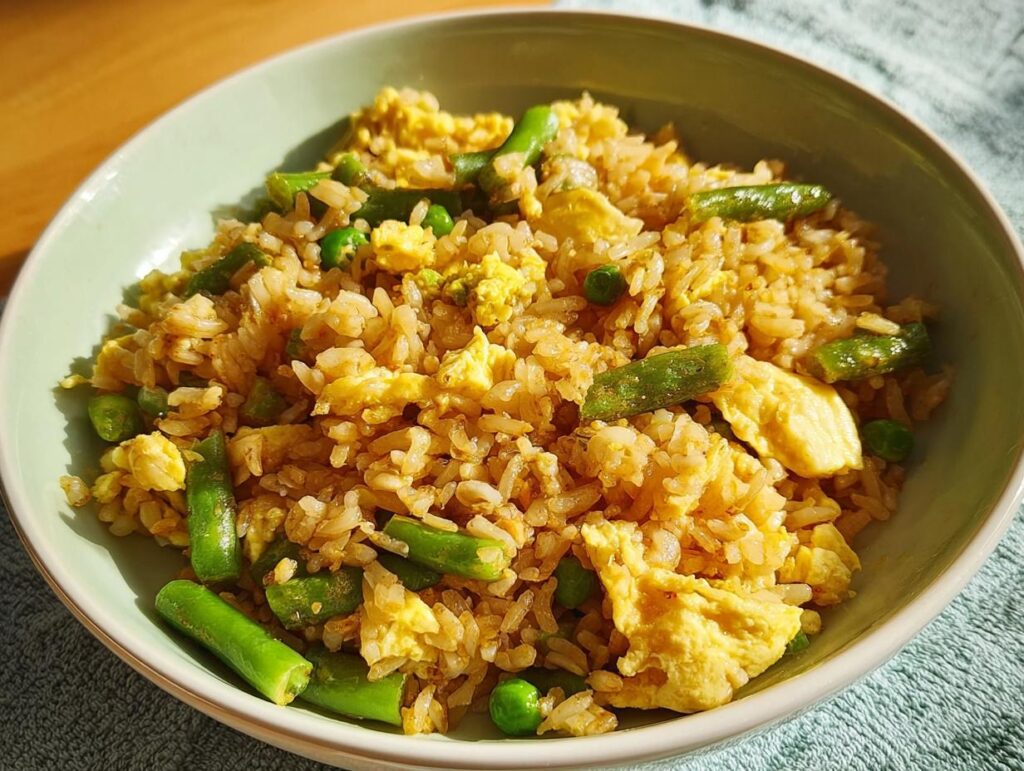A bowl of delicious egg fried rice with green beans and peas, a perfect 7-ingredient egg recipe.