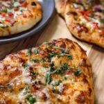 Close-up of a freshly baked homemade pizza with melted cheese and herbs, perfect for pizza night recipes.