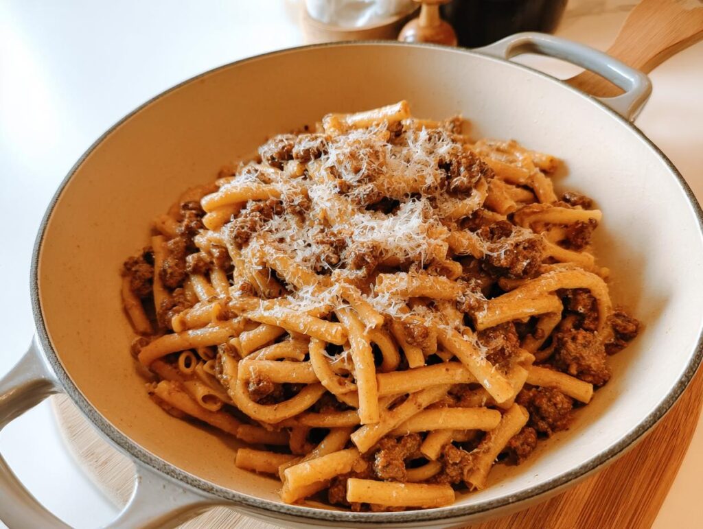 A close-up of a pasta dish with a rich meat sauce and grated cheese, perfect for busy weeknights.