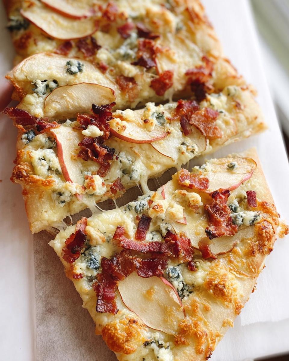Close-up of a slice of pear and bacon pizza with blue cheese and melted mozzarella.