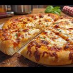 A freshly baked cheese pizza, sliced and ready to serve, perfect for restaurant-style pizza night recipes at home.