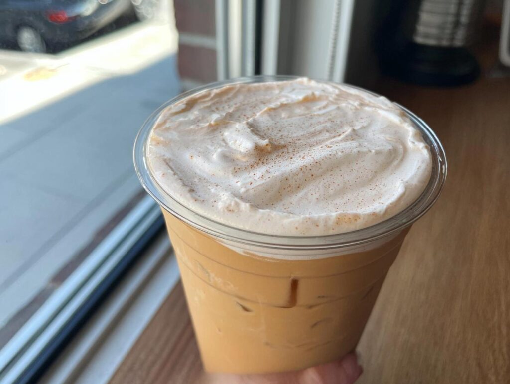 Close-up of an iced coffee drink with whipped cream and cinnamon, a restaurant-style Starbucks drink recipe.