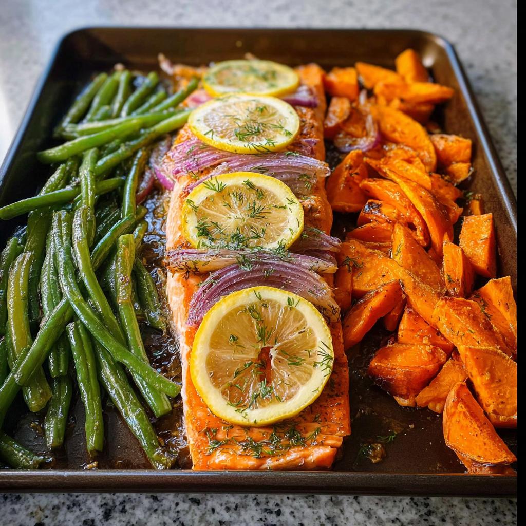 A delicious sheet pan meal prep featuring baked salmon with lemon and red onion, roasted sweet potato wedges, and seasoned green beans.