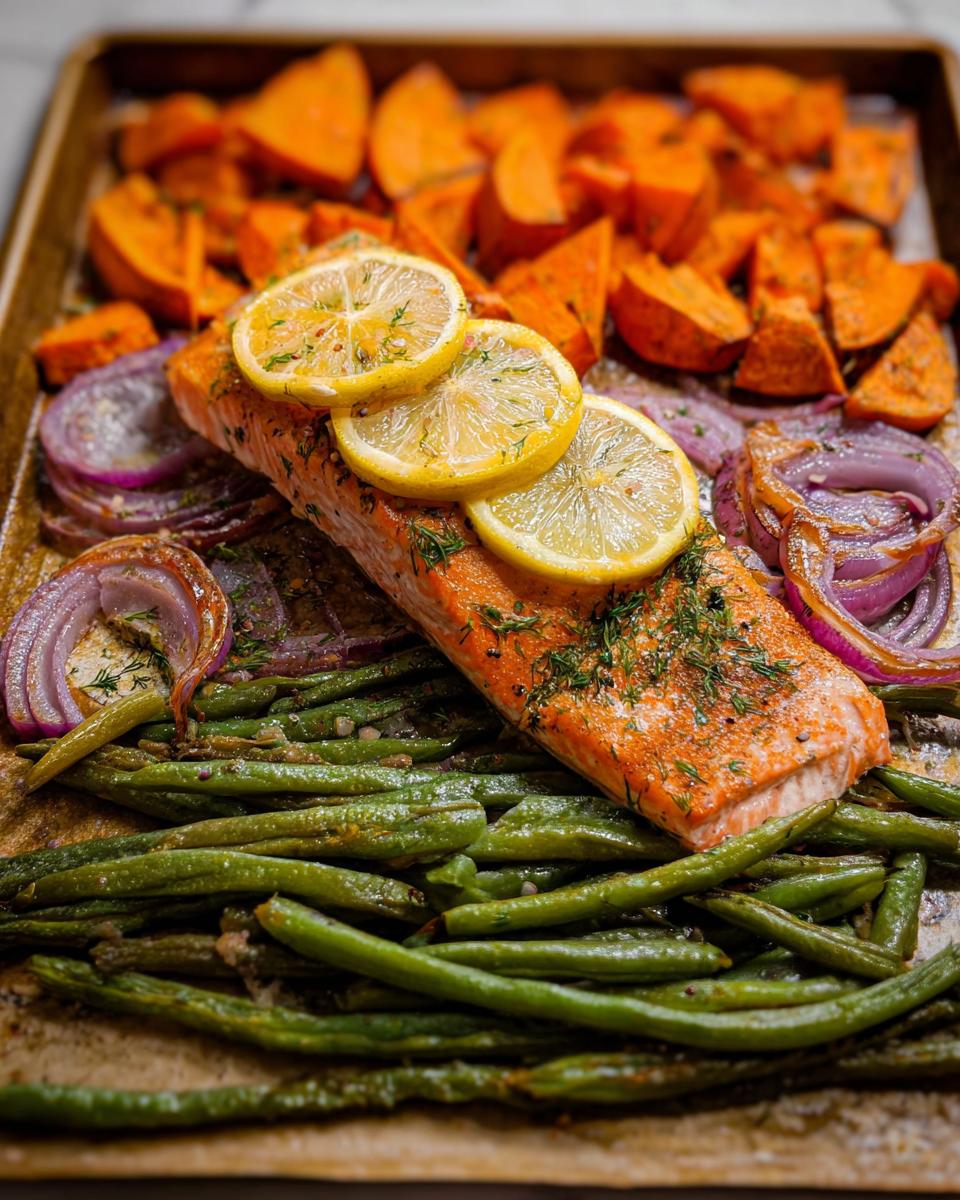 A delicious and healthy sheet pan meal prep featuring salmon, sweet potato wedges, red onion, and green beans, topped with lemon slices.