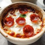 A close-up of a baked Cottage Cheese Pizza Bowl topped with melted cheese and pepperoni slices.