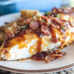 A mouthwatering slice of Cowboy BBQ Bacon Cheddar Chicken, topped with crispy bacon and drizzled with BBQ sauce.