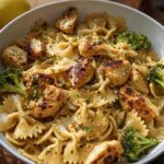 A bowl of Cowboy Butter Lemon Bowtie Chicken Pasta with Broccoli, featuring tender chicken pieces and vibrant broccoli florets.