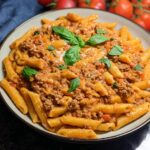 A bowl of Creamy High Protein Beef Pasta, garnished with fresh basil leaves.
