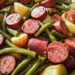Close-up of a Crockpot Kielbasa and Green Beans dish with sliced kielbasa, potatoes, and green beans.