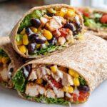 Close-up of a healthy Southwest Chicken Wrap filled with chicken, black beans, corn, lettuce, and a creamy dressing.