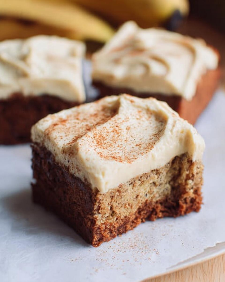 Close-up of a slice of Banana Bread Brownies Made Easy, topped with cream cheese frosting and cinnamon.