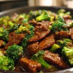 Close-up of tender slices of beef and vibrant broccoli florets coated in a savory sauce, a classic Chinese Beef and Broccoli dish.