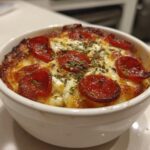 A close-up of a baked Cottage Cheese Pizza Bowl topped with melted cheese and pepperoni slices.