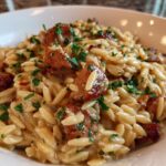 Close-up of a bowl of Creamy Chicken Sausage Orzo, garnished with fresh parsley.
