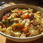 A close-up of a bowl filled with delicious Egg Roll in a Bowl, featuring ground meat, cabbage, and carrots.